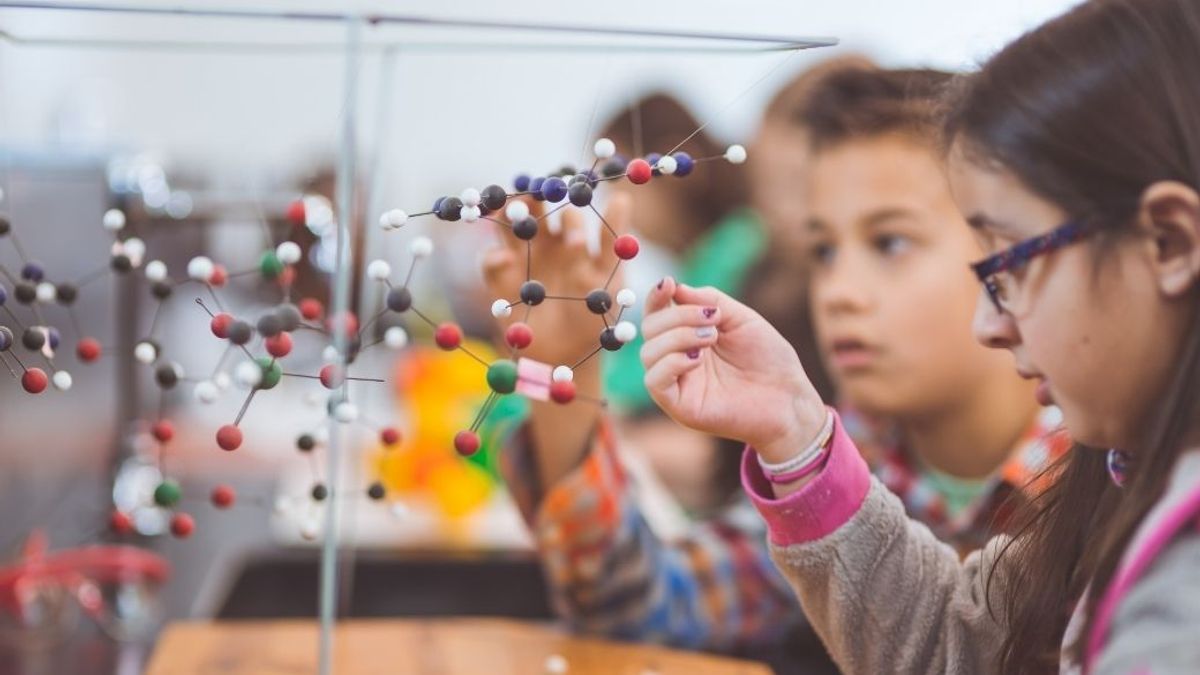 Kids playing with a molecule science project in class