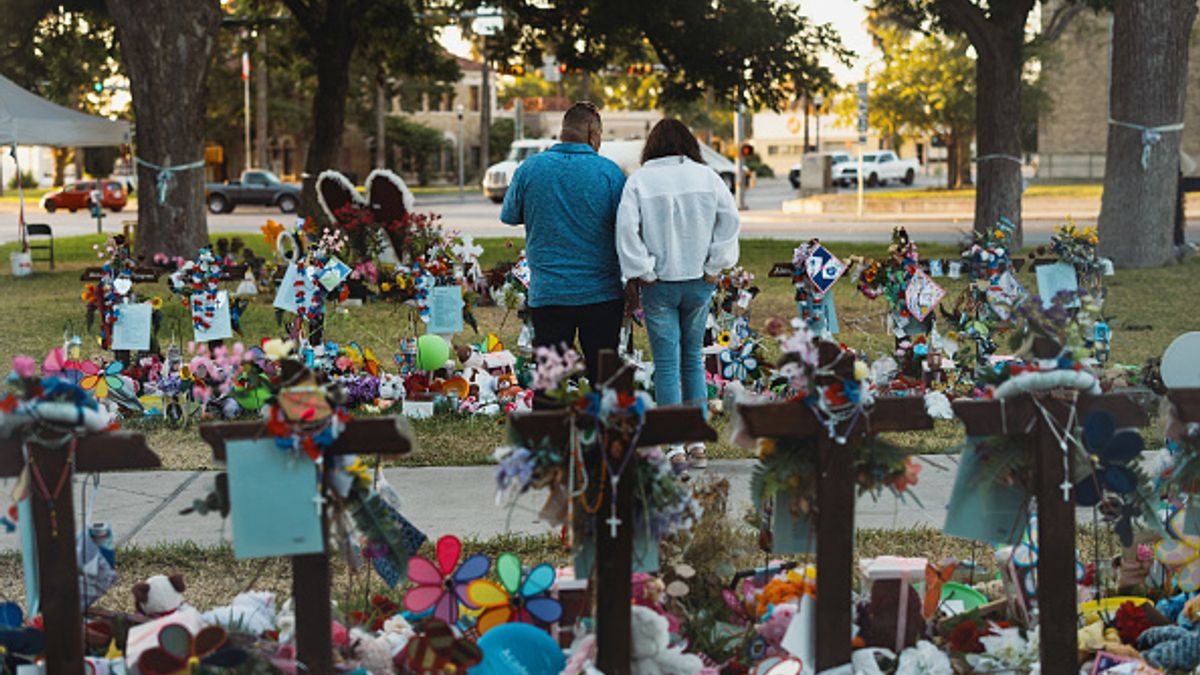A couple stands among a memorial for the children and teachers killed on May 24, at Robb Elementary School in Uvalde, Texas