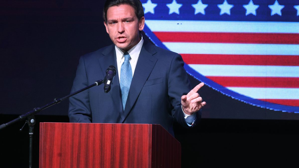 Photo of a man in a suit speaking at a podium.