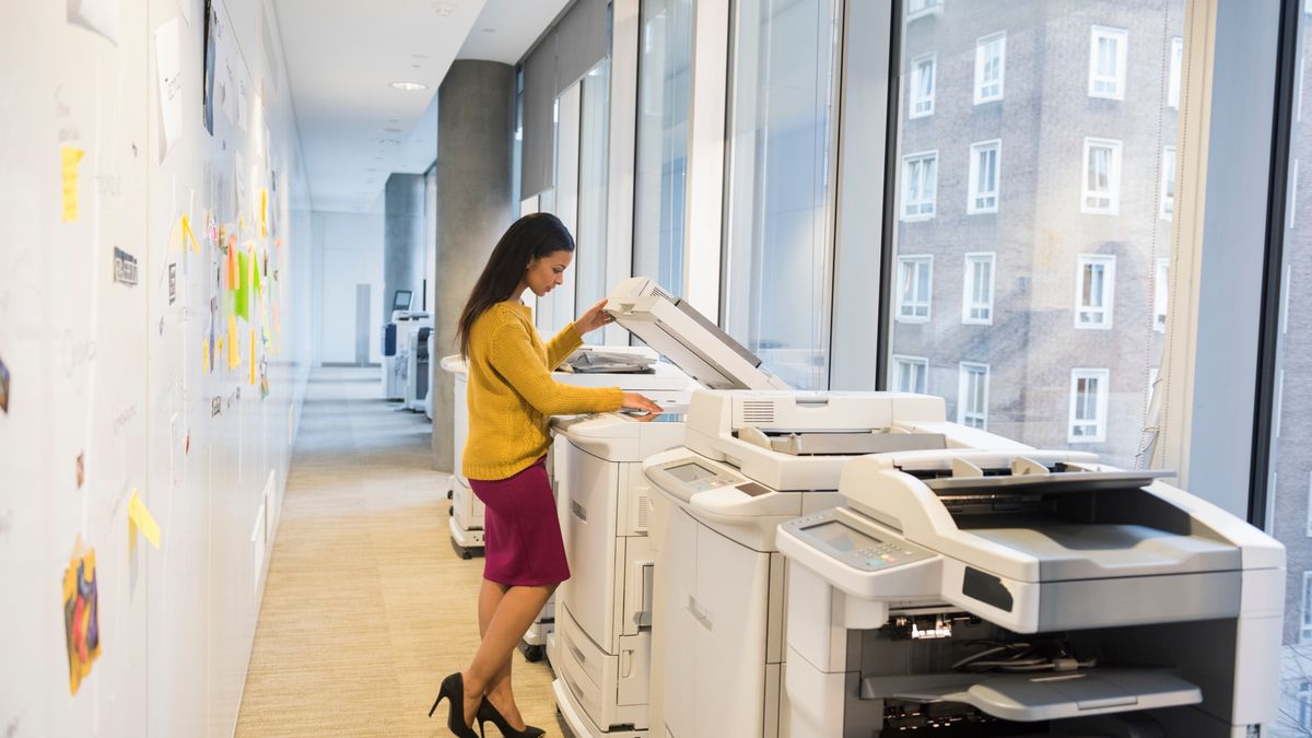 Professional using a printer in a high-rise office building.