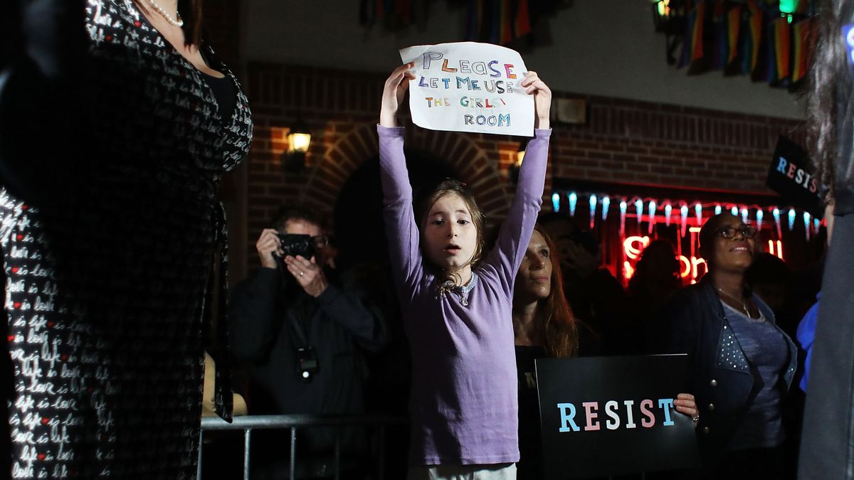 A child holds a sign that read, "please let me use the girl's room."