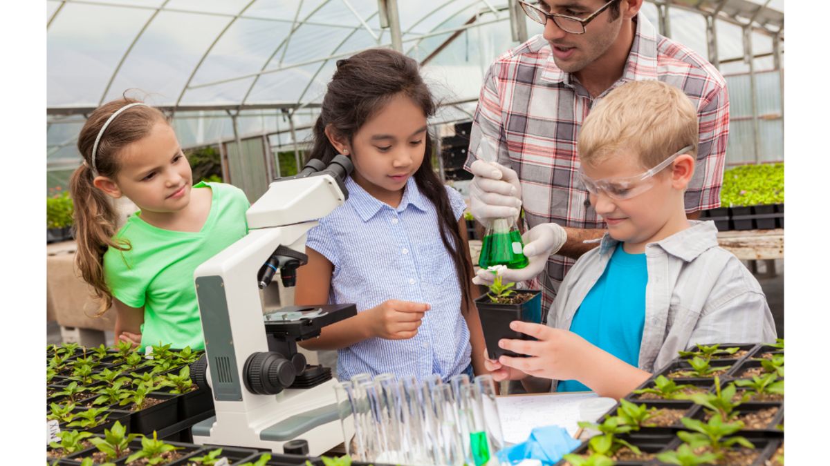 Kids in a greenhouse conducting an experiment with an adult instructor