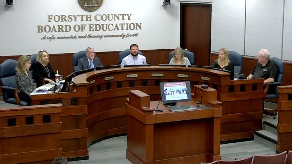 Members of Forsyth County Board of Education sit during a school board meeting