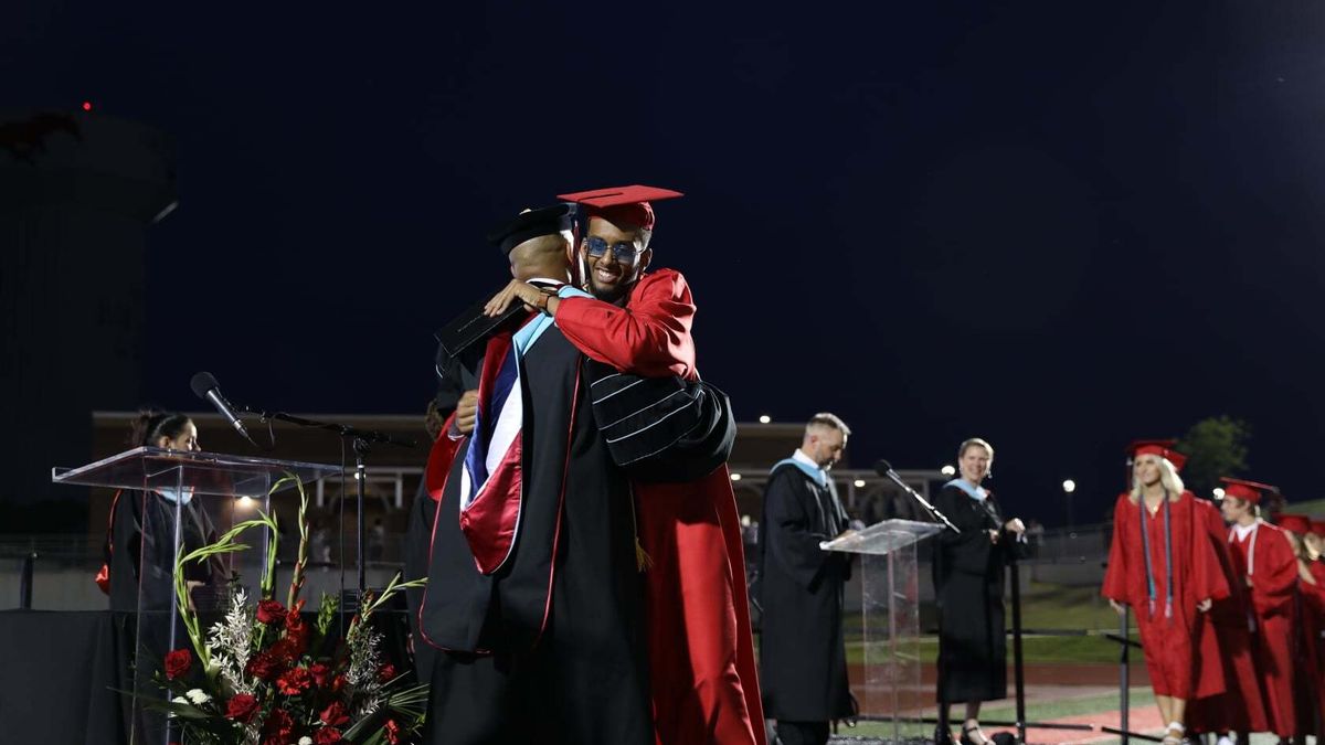 Former principal James Whitfield embraces a student during a graduation ceremony at his Colleyville Heritage High School in Texas.